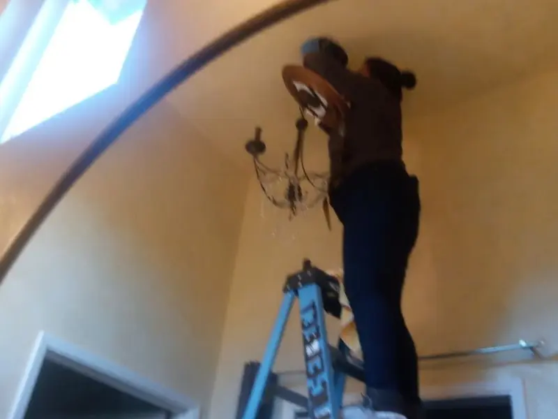 Electrician installing a chandelier in a Inglewood residence
